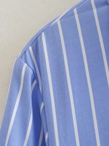 Détail macro du tissu à rayures bleues et blanches montrant les coutures de l'épaule