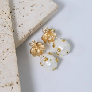 Vintage gold bee earrings with freshwater pearls and amethyst tassels on beige stone