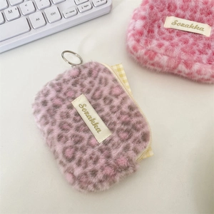 Macro view of plush leopard print storage bag with metal zipper and Sozakka tag