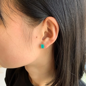 Close-up of emerald-cut green zircon stud earrings on model in S925 sterling silver