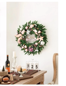 Détail des ornements roses et blancs sur une couronne de Noël illuminée avec signe Merry Christmas