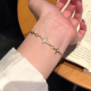 Close-up of an 18k gold plated star bracelet with zircon stones worn on a wrist