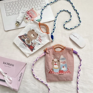 Détail de la broderie ours sur mini sac en tissu oxford avec bandoulière tressée