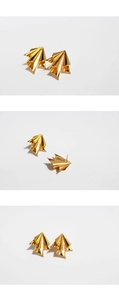 Macro details of gold irregular crinkled metal earrings with artistic geometric design