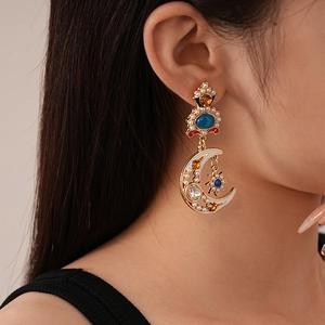 Detail of vintage moon and star earrings with pearls and colorful rhinestones on model