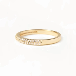 Close-up of a gold dual-row pavé diamond ring with a polished metallic finish