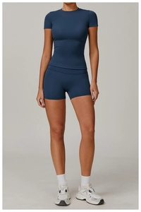Front view of a navy blue short-sleeve athletic set with high-waist yoga shorts on model