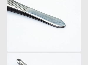 Close-up of silver stainless steel eyelash tweezers with brushed metal texture details