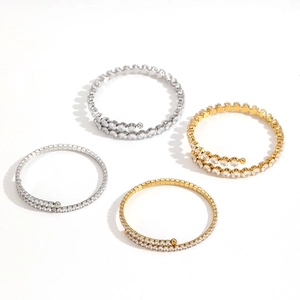 Elegant gold and silver spiraled bracelets with pavé zircons in a flat lay view