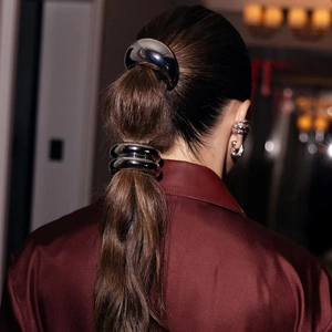Polished silver metal hair rings and matching layered hoop earrings worn by a model