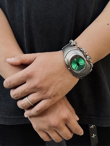 Detail of silver Y2K watch with green dial and matching dice chain bracelet