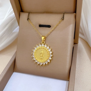 Macro shot of gold sunburst Virgin Mary pendant with sparkling white zircons in a box