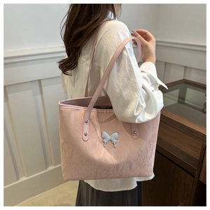 Detailed close-up of pink tote bag with pleated texture and silver butterfly ornament