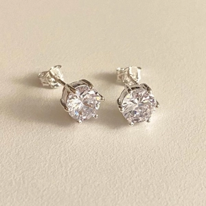 Macro detail of 925 sterling silver hallmark on classic six-prong zircon stud earrings