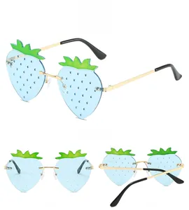 Detailed views of strawberry-shaped sunglasses with blue lenses and gold frames