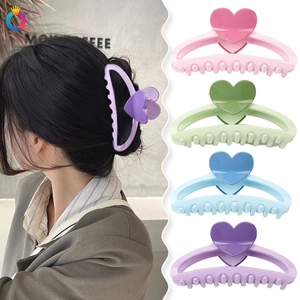 Detail of sweet heart-shaped hair claw clips in pastel colors with model showcase