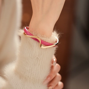 Detail of double-layer wave bangle with gold plating and vibrant magenta enamel finish