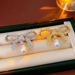 Broches nœud élégantes en or et argent avec diamants pavés et perles en goutte