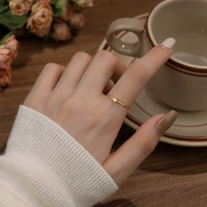 Elegant gold S925 silver minimalist ring with single white zircon worn on a hand