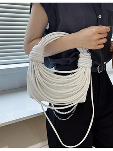 Unique white knotted shoulder bag with pearl chains and crossbody strap shown on a model