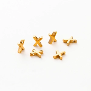 Close-up of gold vacuum plated letter X beads for DIY jewelry making accessories