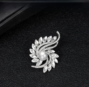 Detail of silver brooch with large central pearl and sparkling marquise-cut rhinestones