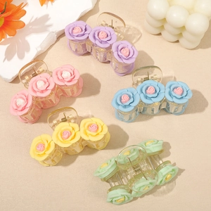 Pink camellia hair claw clips in five pastel colors on a decorative aesthetic background
