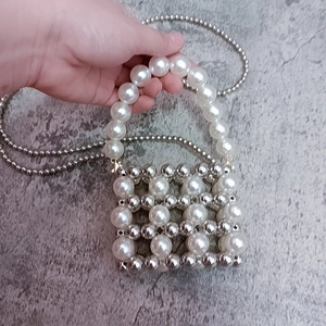 Detailed macro of a mini handbag crafted from white pearls and silver metal beads