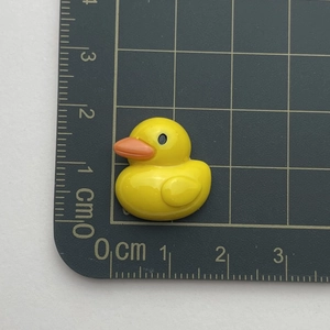 Top view of mini resin yellow duck charm on scale mat showing 2cm size detail