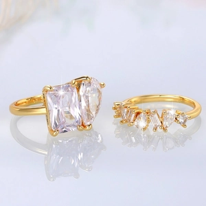 Macro detail of gold two-piece ring set with emerald and pear-cut cubic zirconia