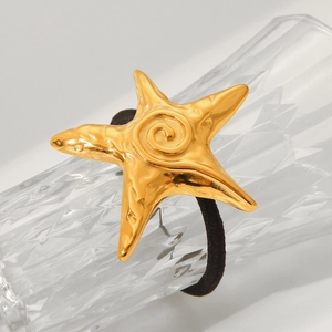 Golden starfish pendant on black elastic hair tie wrapped around a glass bottle