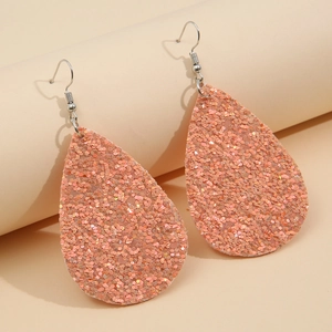 Orecchini a goccia glitter color pesca con ganci argentati su supporto minimalista