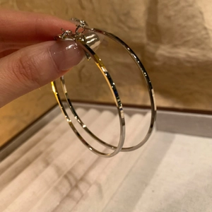 Minimalist large silver circle hoop earrings with high-polished metallic finish