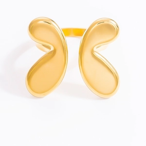 Close-up of golden stainless steel ring with abstract petal texture and mirror finish