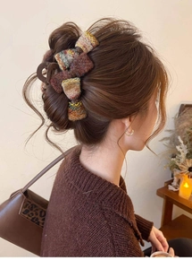 Détail d'une pince à cheveux en tweed avec nœud portée en chignon français