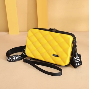 Yellow hard shell crossbody bag with quilted texture and adjustable black printed strap