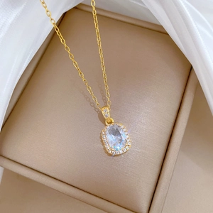 Close-up of gold chain necklace featuring a rectangular zircon pendant with small diamonds