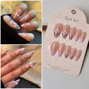 Pink press on nails with cherry charms, leopard patterns and pearl bows stiletto style