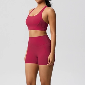 Detail view of high-waisted yoga shorts with side pocket in berry red stretch fabric
