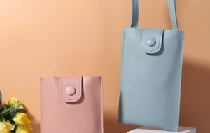 Detailed view of mini crossbody phone bags in blue and pink with litchi grain texture