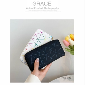 Close-up of geometric pattern wallet with gold zipper holding multiple cards and phone