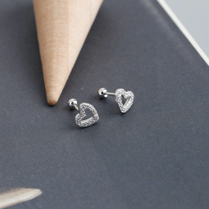 Macro detail of heart-shaped silver earrings with cubic zirconia and screw back