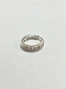 Macro shot of silver metal hoop earrings set with six square clear zircon stones