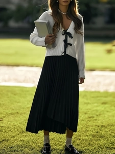 Cardigan in maglia con fiocco e gonna a pieghe nera per un look preppy dolce