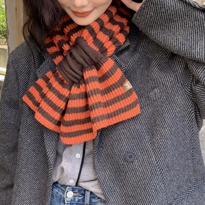 Knitted striped wool blend scarf for women featuring orange and brown crisscross patterns