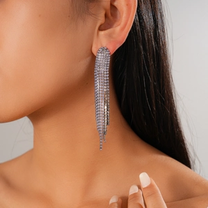 Dettaglio degli orecchini a nappa geometrici lunghi con strass su una modella