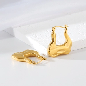 Gros plan de boucles d'oreilles croissant en U avec un éclat métallique doré sur pierre