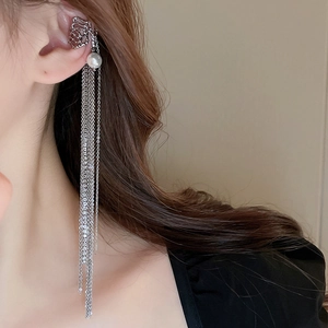 Detail of silver long tassel ear cuff with rhinestones and white pearl on model's ear