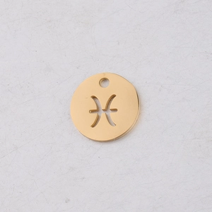 Close-up of golden circular Pisces zodiac pendant with hollowed-out metal design