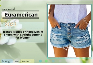 Dettaglio macro di pantaloncini in denim azzurro con fori strappati e orlo a frange